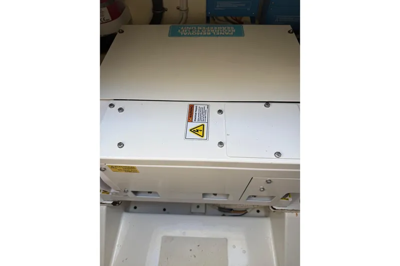 Prawn Star Yacht Photos Pics Engine compartment of 2022 Tiara Yachts 34 LX, featuring electrical components and warning labels.