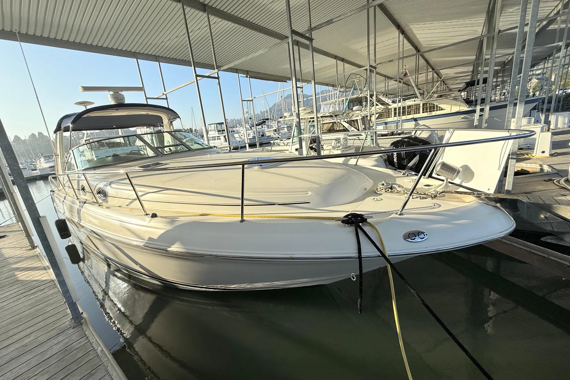 2001 Sea Ray 340 Sundancer docked in a marina under a covered structure.