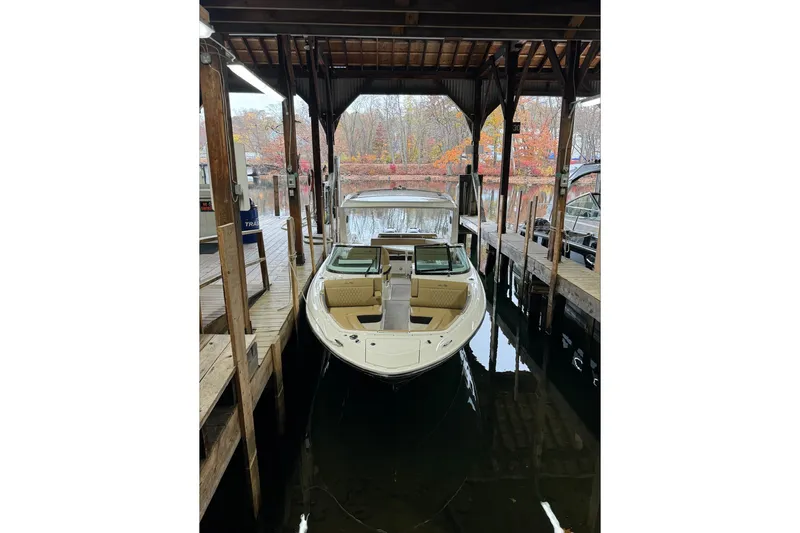  Yacht Photos Pics 2019 Sea Ray SLX 310 Outboard docked under a wooden shelter in autumn setting.