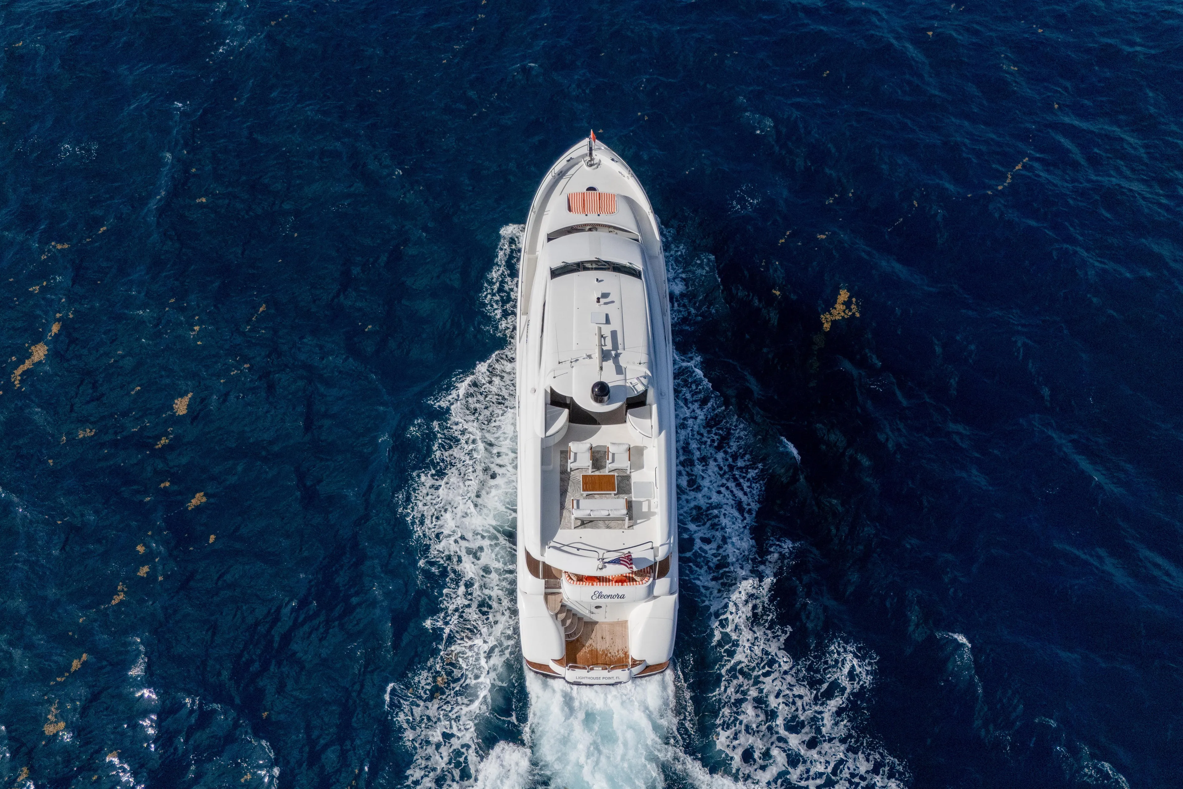 Aerial view of 2004 Lazzara 80 SL yacht cruising on deep blue ocean.