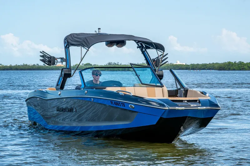  Yacht Photos Pics 2022 MasterCraft X26 boat cruising on a sunny day, featuring sleek design and modern amenities.