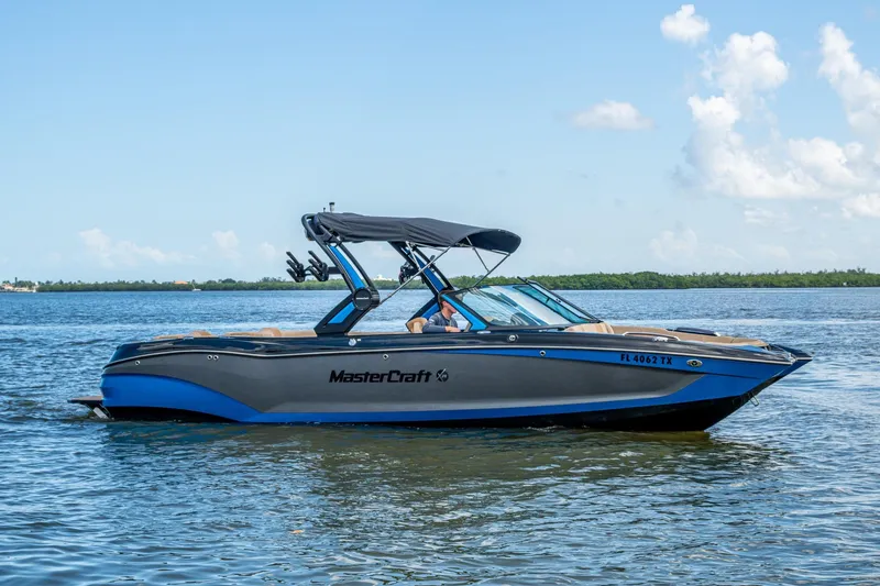  Yacht Photos Pics 2022 MasterCraft X26 boat on calm water, featuring sleek design and blue accents.