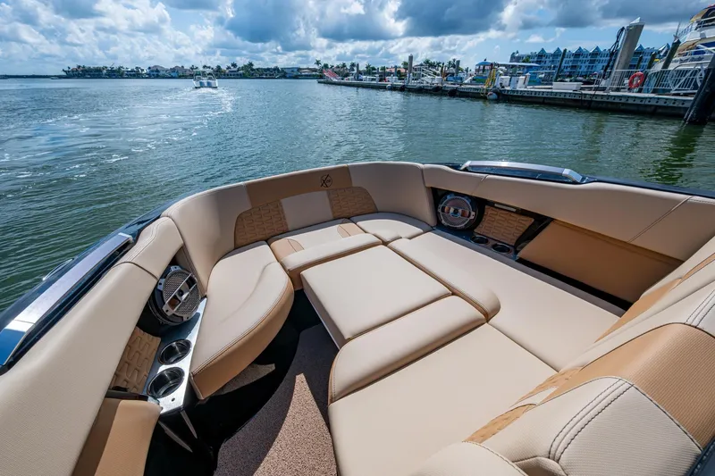  Yacht Photos Pics Luxurious seating on 2022 MasterCraft X26 boat, docked by a scenic waterfront.