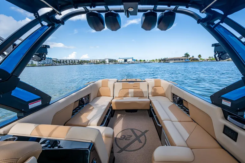  Yacht Photos Pics 2022 MasterCraft X26 boat interior with luxurious seating on a scenic lake.