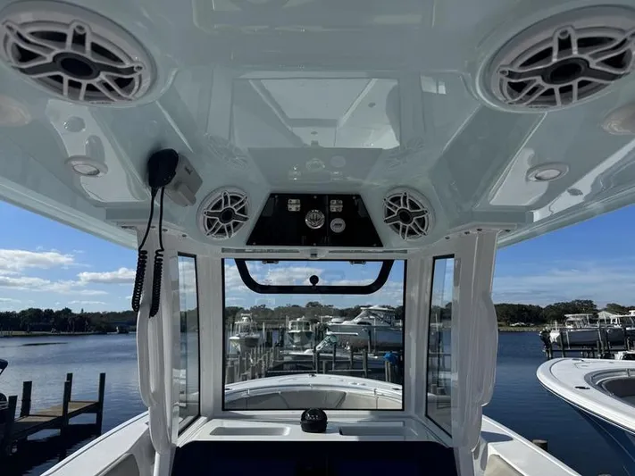  Yacht Photos Pics Interior view of 2025 Sportsman Heritage 26 boat, featuring modern controls and speakers.