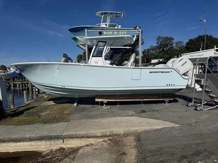  Yacht Photos Pics 2025 Sportsman Heritage 26 boat docked near a bait shop under clear skies.