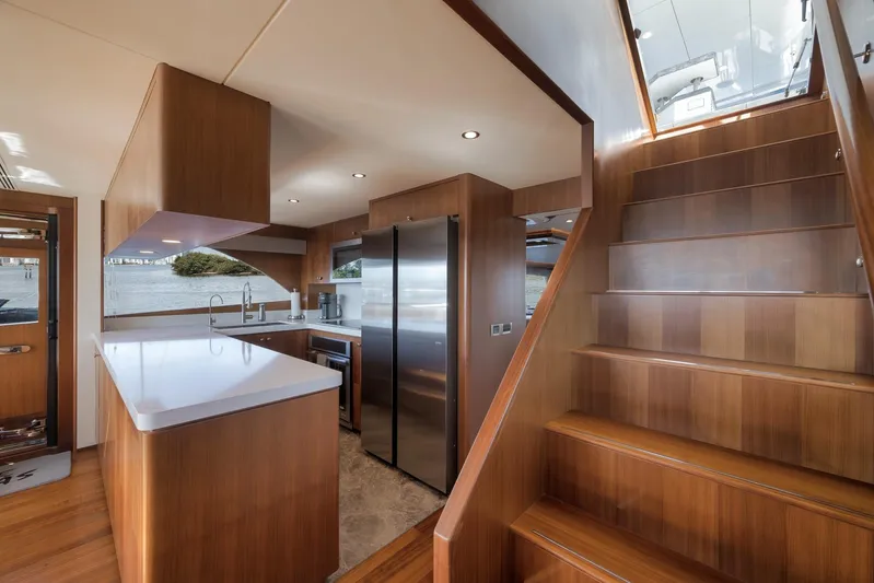 Live Mas Yacht Photos Pics Luxurious kitchen and staircase on 2017 Ocean Alexander 85 E yacht, featuring modern wood finishes.