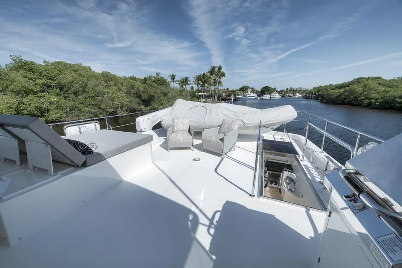 Live Mas Yacht Photos Pics Luxurious 2017 Ocean Alexander 85 E yacht deck with seating, surrounded by serene waterway and greenery.