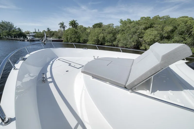 Live Mas Yacht Photos Pics Luxurious 2017 Ocean Alexander 85 E yacht with sunbed on deck, surrounded by lush greenery.