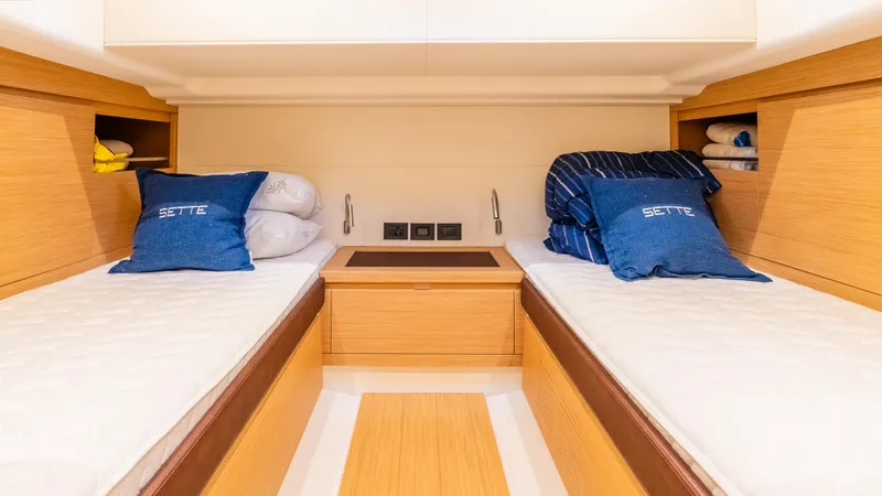  Yacht Photos Pics Twin cabin interior of 2021 Pardo Yachts P43, featuring wooden finishes and blue cushions.
