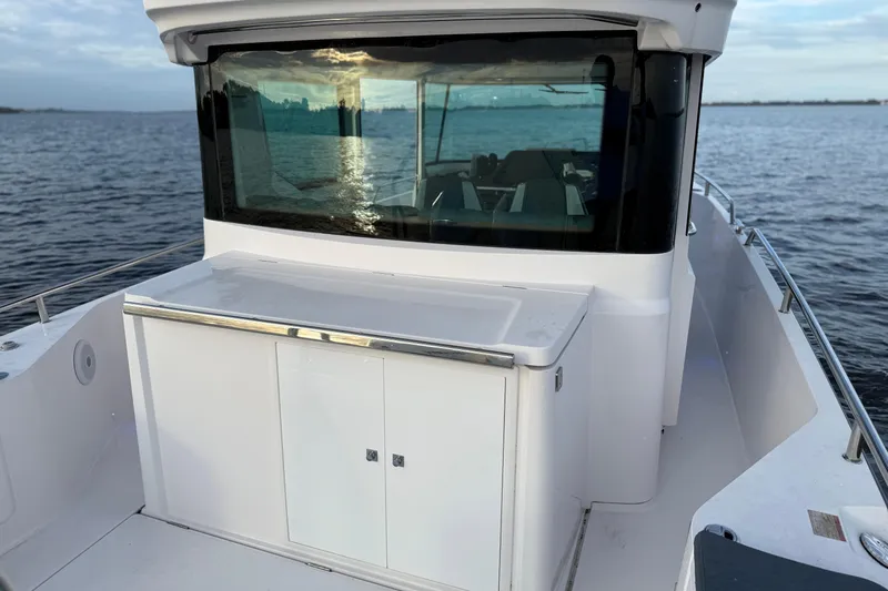  Yacht Photos Pics 2022 Axopar 28 Cabin boat on calm water, showcasing sleek design and modern cabin.