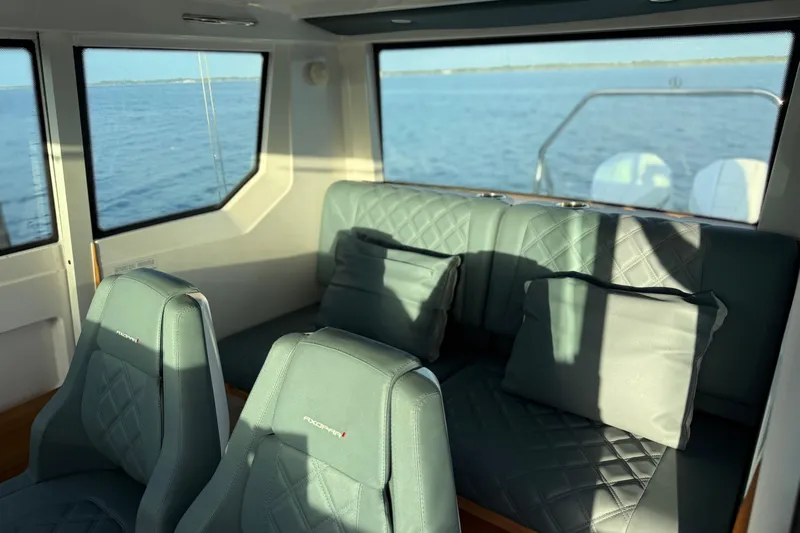 Yacht Photos Pics Interior of 2022 Axopar 28 Cabin with plush seating and ocean view.