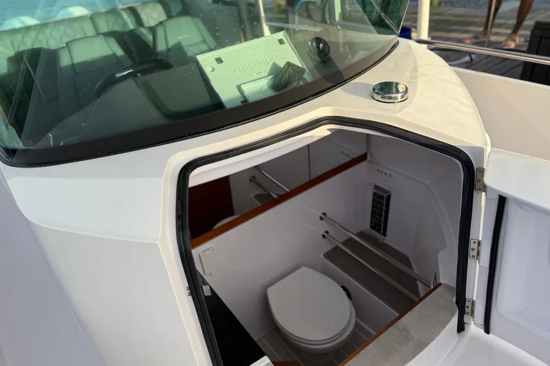  Yacht Photos Pics 2022 Axopar 28 Cabin boat interior with visible toilet and seating area.