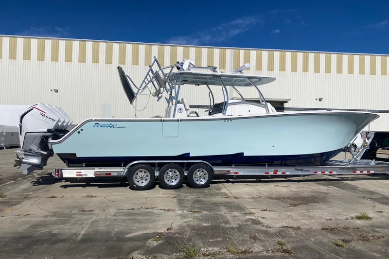  Yacht Photos Pics 2022 Front Runner 39 CC boat on trailer, parked outdoors near a warehouse.