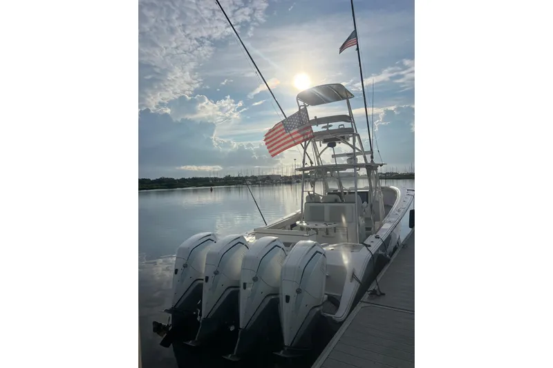  Yacht Photos Pics 2022 Front Runner 39 CC boat docked, featuring four engines and American flags, under a bright sky.