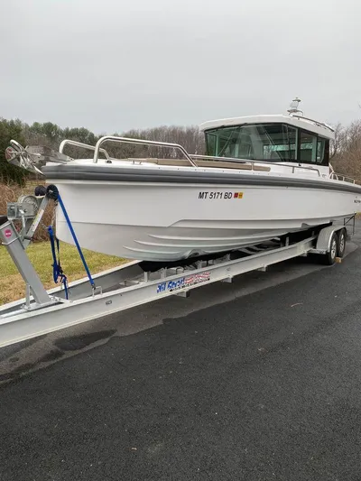  Yacht Photos Pics 2019 Axopar 28 CABIN boat on trailer, parked on asphalt road.