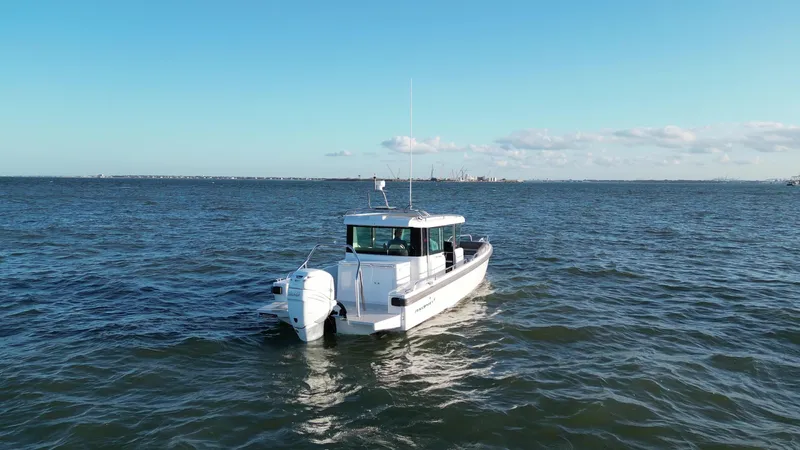  Yacht Photos Pics 2019 Axopar 28 CABIN boat cruising on open water under clear skies.