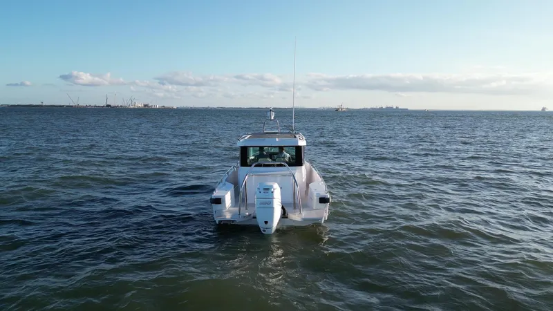  Yacht Photos Pics 2019 Axopar 28 CABIN boat on open water, viewed from the rear.
