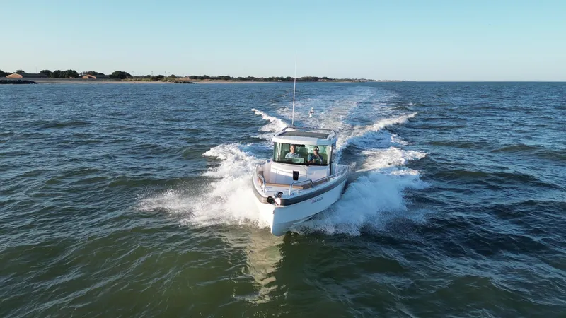 Yacht Photos Pics 2019 Axopar 28 CABIN boat cruising on open water, creating a dynamic wake.
