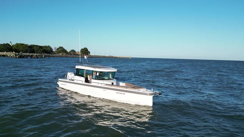  Yacht Photos Pics 2019 Axopar 28 CABIN boat cruising on open water under clear blue sky.