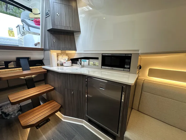 37 Sea Ray Sundancer Ob 2023 Yacht Photos Pics 2023 Sea Ray Sundancer 370 OB interior with kitchenette, wooden stairs, and modern appliances.