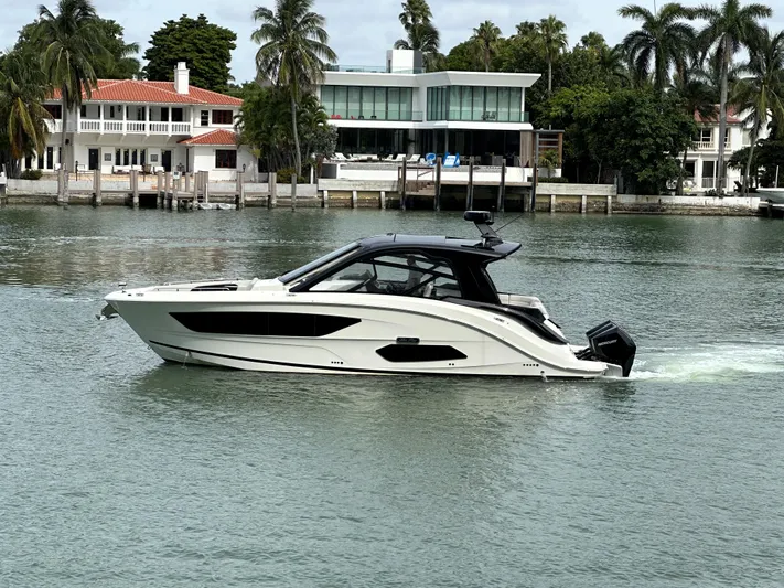 37 Sea Ray Sundancer Ob 2023 Yacht Photos Pics 2023 Sea Ray Sundancer 370 OB cruising on a calm waterfront with luxury homes in the background.