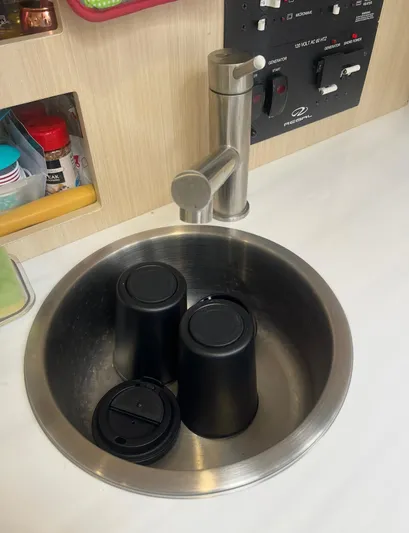  Yacht Photos Pics Stainless steel sink with black cups in a 2024 Regal 26 XO boat interior.