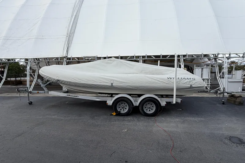  Yacht Photos Pics 2023 Williams Jet Tenders Dieseljet 625 covered on trailer, parked outdoors.