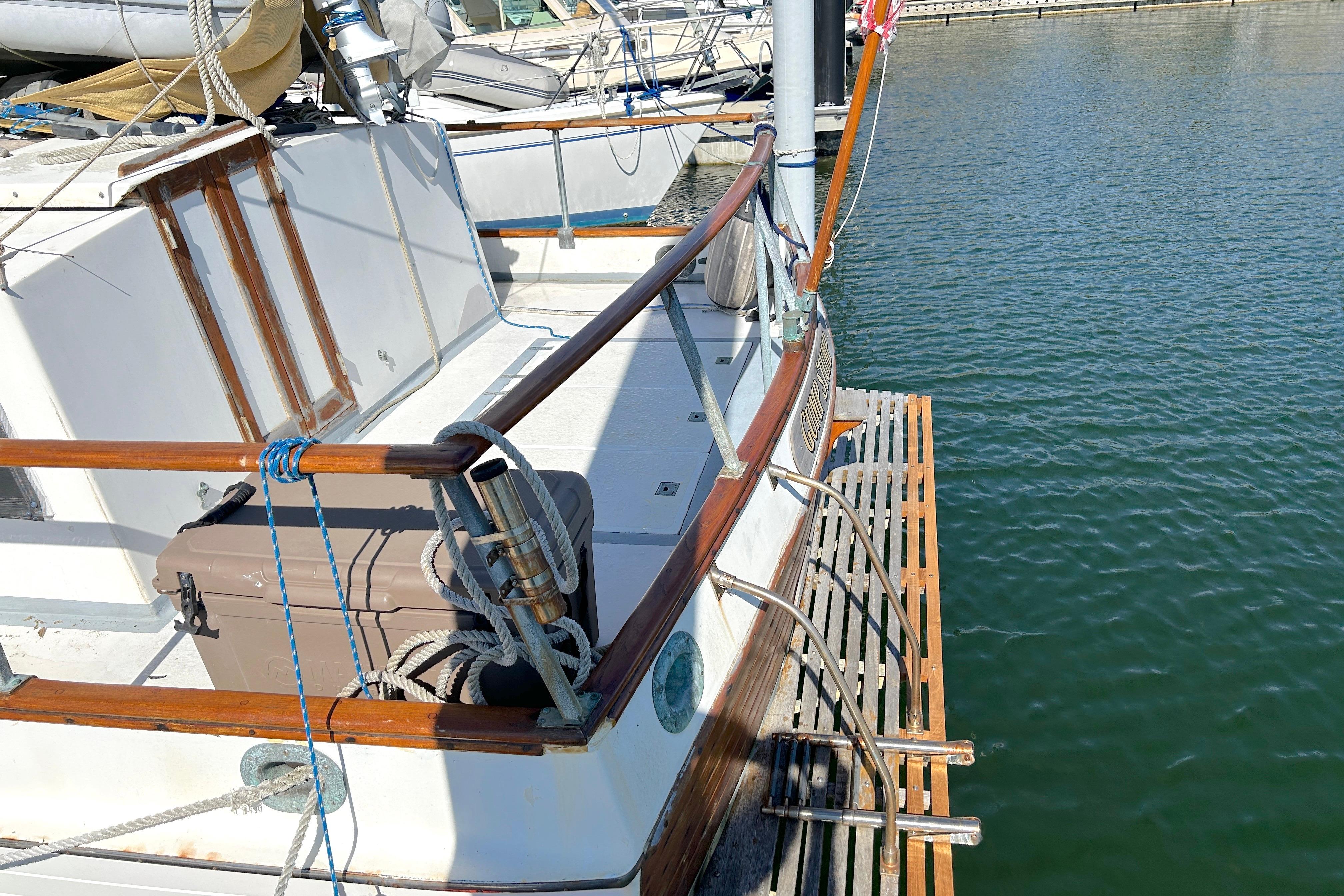 1988 Grand Banks 36 Classic yacht docked, featuring wooden railings and deck details.