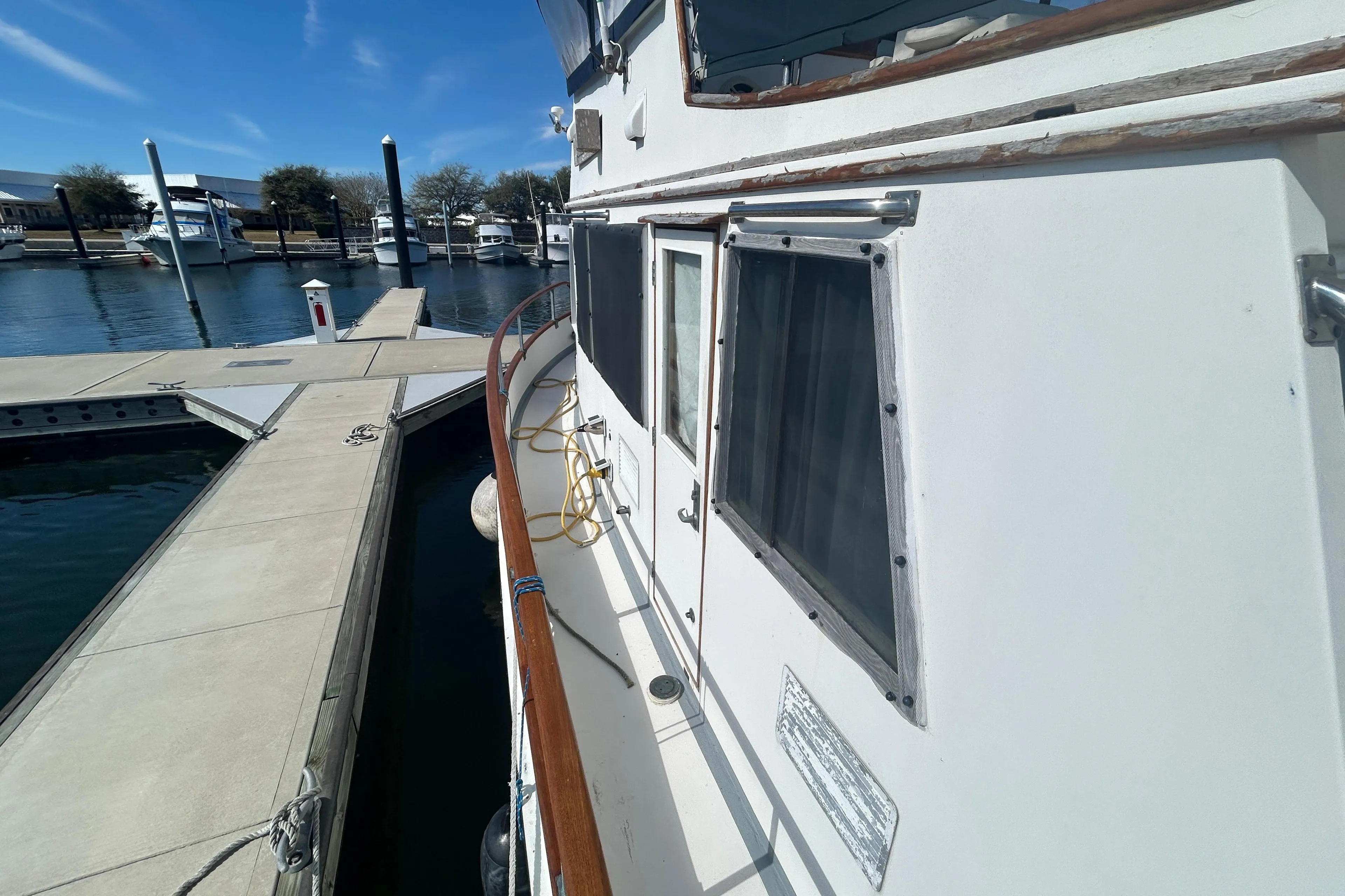 1988 Grand Banks 36 Classic yacht docked at marina under clear blue sky.