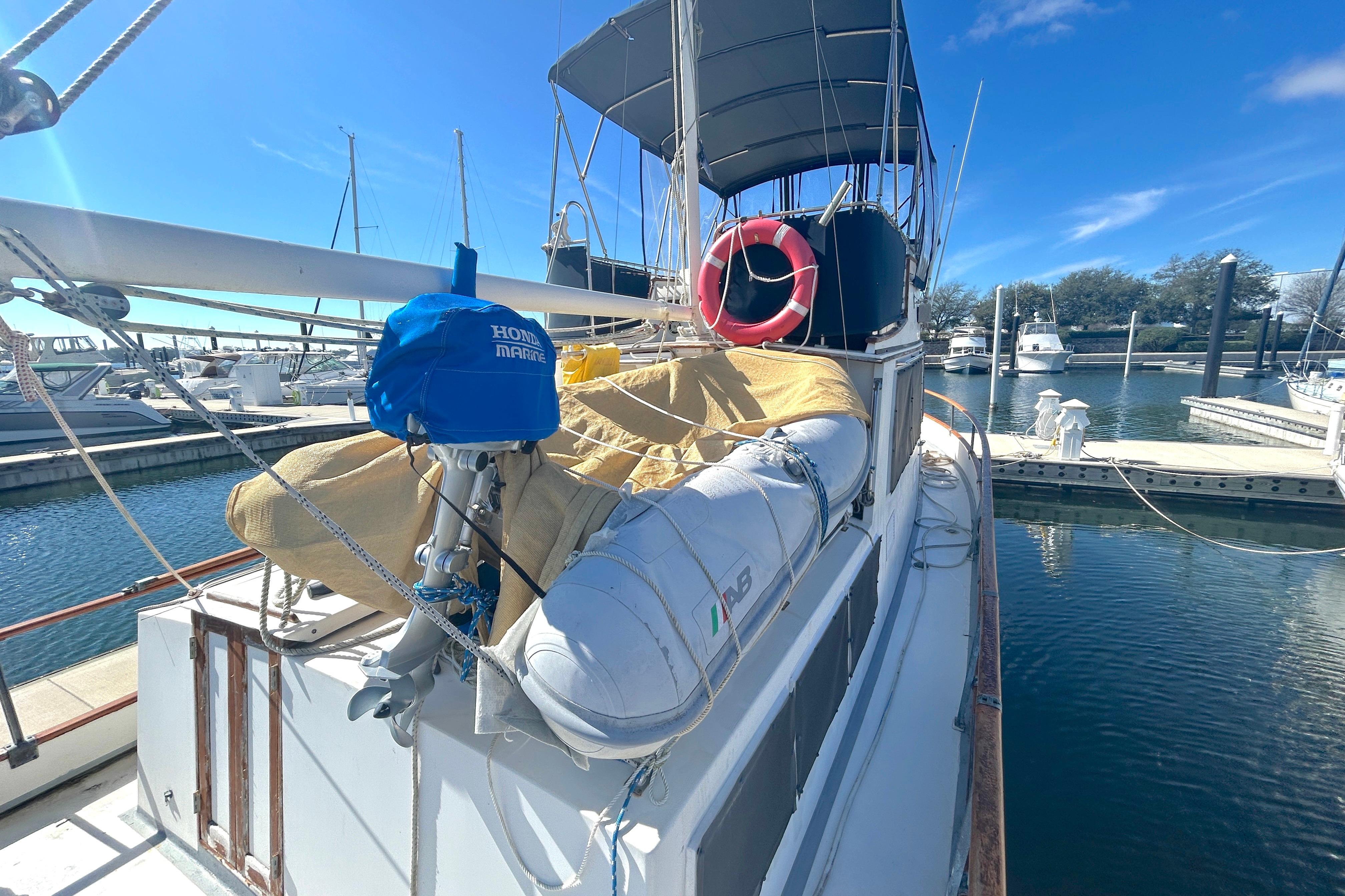 1988 Grand Banks 36 Classic yacht docked, featuring a covered deck and lifebuoy.