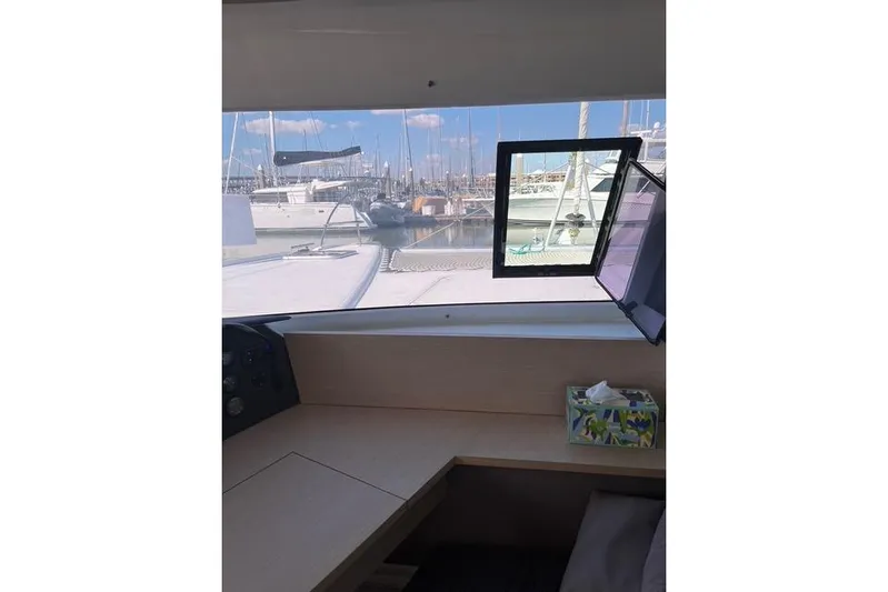 Akua Yacht Photos Pics Interior view from a 2018 Fountaine Pajot Helia 44 Evolution catamaran, overlooking a marina.