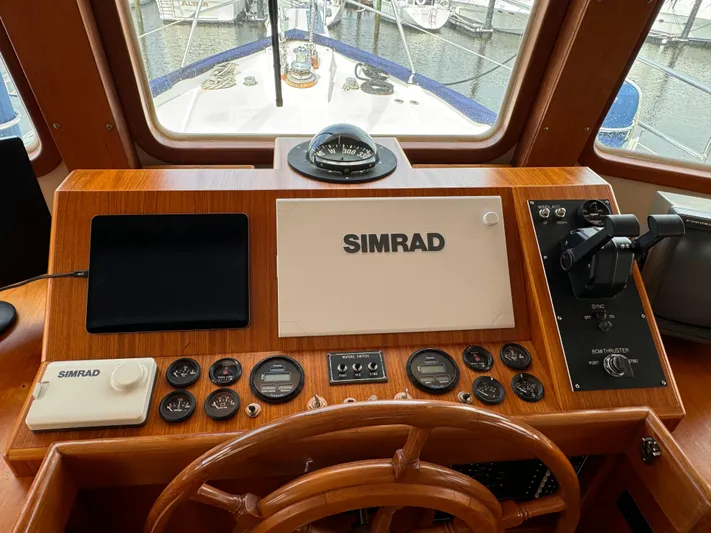 Dyer Need Yacht Photos Pics Helm of 1996 Kadey-Krogen 48 with Simrad navigation equipment and wooden steering wheel.
