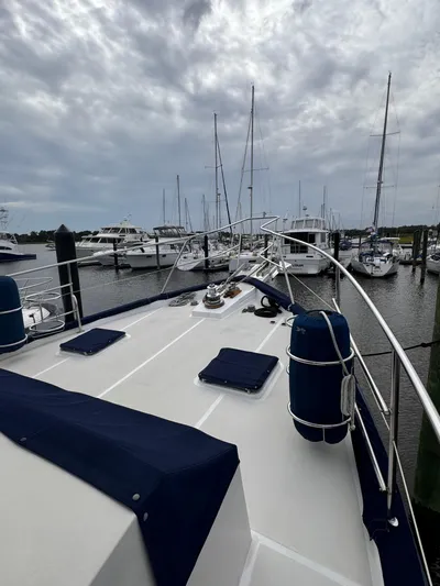 Dyer Need Yacht Photos Pics Kadey-Krogen 48 yacht deck, 1996 model, docked at marina under cloudy sky.