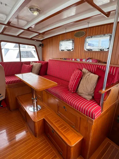 Dyer Need Yacht Photos Pics Interior of 1996 Kadey-Krogen 48 yacht with red-striped seating and wooden finishes.
