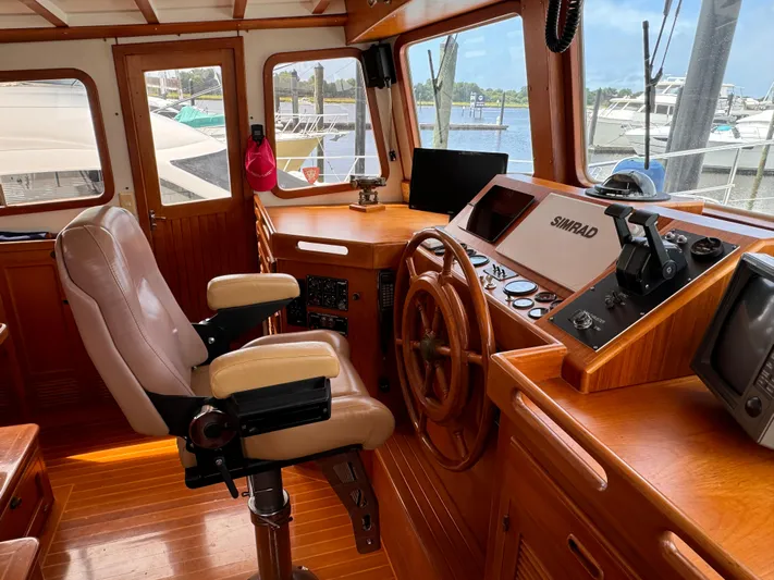 Dyer Need Yacht Photos Pics Interior of 1996 Kadey-Krogen 48 yacht with wooden helm and navigation equipment.