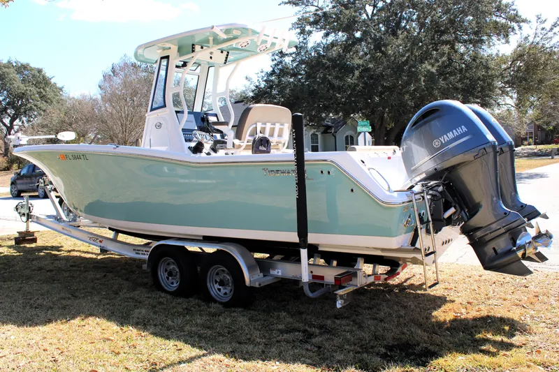  Yacht Photos Pics 2022 Tidewater 272 CC Adventure boat on trailer with Yamaha engine, parked outdoors.