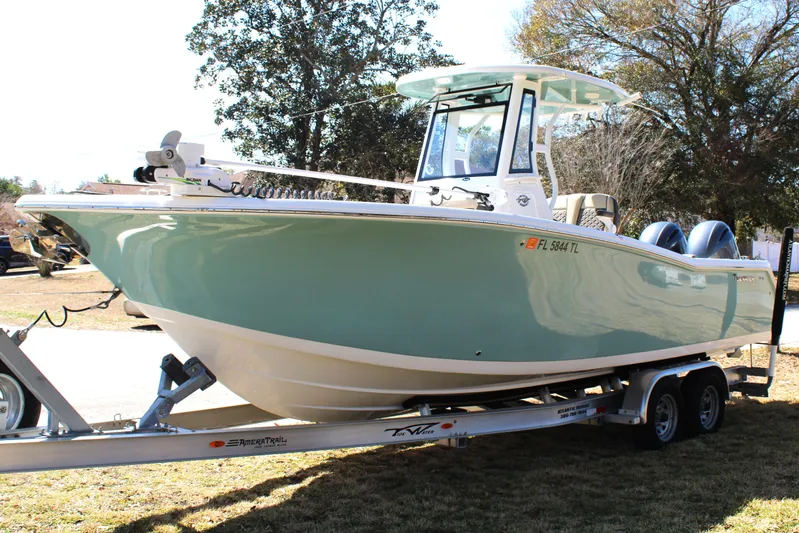  Yacht Photos Pics 2022 Tidewater 272 CC Adventure boat on trailer, parked outdoors.