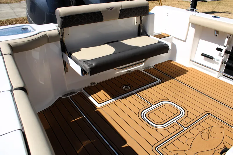  Yacht Photos Pics 2022 Tidewater 272 CC Adventure boat interior with cushioned seating and teak-style flooring.
