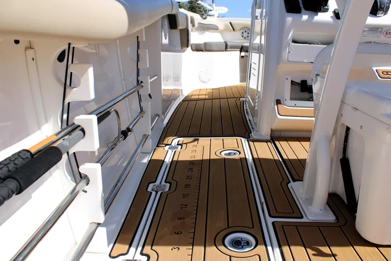  Yacht Photos Pics 2022 Tidewater 272 CC Adventure boat interior with teak flooring and fishing rod holders.