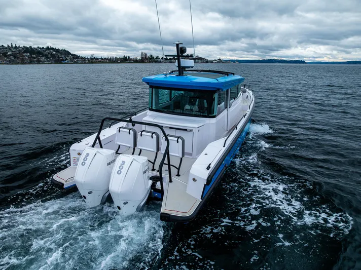 Aqvavit Yacht Photos Pics 2021 Axopar 37xc Wetbar cruising on open water under cloudy skies.