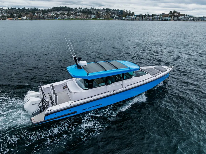 Aqvavit Yacht Photos Pics 2021 Axopar 37xc Wetbar cruising on open water, showcasing sleek design and vibrant blue accents.
