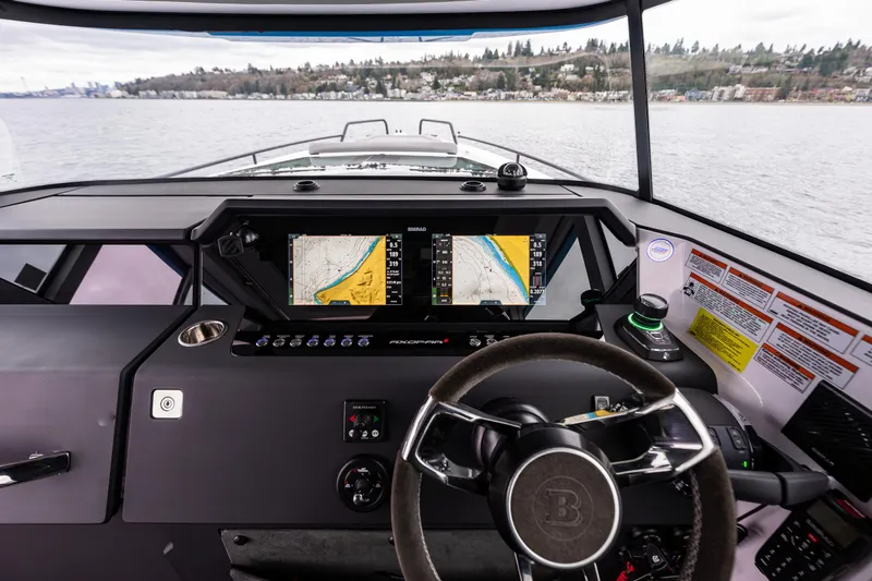 Aqvavit Yacht Photos Pics 2021 Axopar 37xc Wetbar boat dashboard with navigation screens on a calm lake.