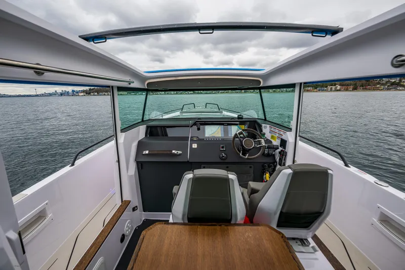 Aqvavit Yacht Photos Pics 2021 Axopar 37xc Wetbar boat interior with steering wheel and seating on water.