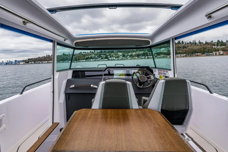Aqvavit Yacht Photos Pics Interior view of 2021 Axopar 37xc Wetbar boat with seating and table on a lake.