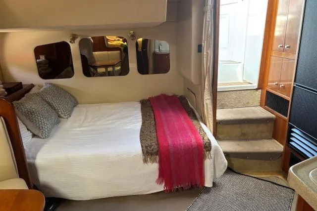  Yacht Photos Pics 2004 Cruisers Yachts 370 Express cabin interior with bed, mirrors, and stairs.