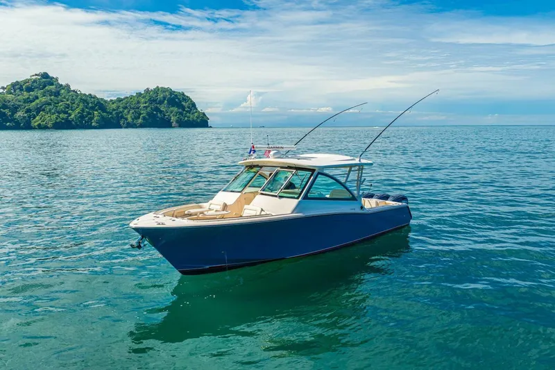 Dos Amigos Yacht Photos Pics 2020 Grady-White Freedom 375 boat on calm ocean with lush island background.