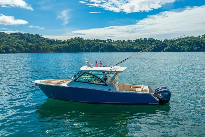 Dos Amigos Yacht Photos Pics 2020 Grady-White Freedom 375 boat on serene water with lush green shoreline.