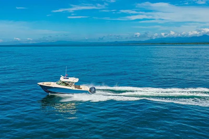 Dos Amigos Yacht Photos Pics 2020 Grady-White Freedom 375 cruising on open blue ocean under clear sky.