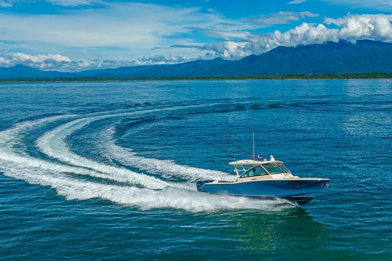 Dos Amigos Yacht Photos Pics 2020 Grady-White Freedom 375 cruising on open water with scenic mountain backdrop.